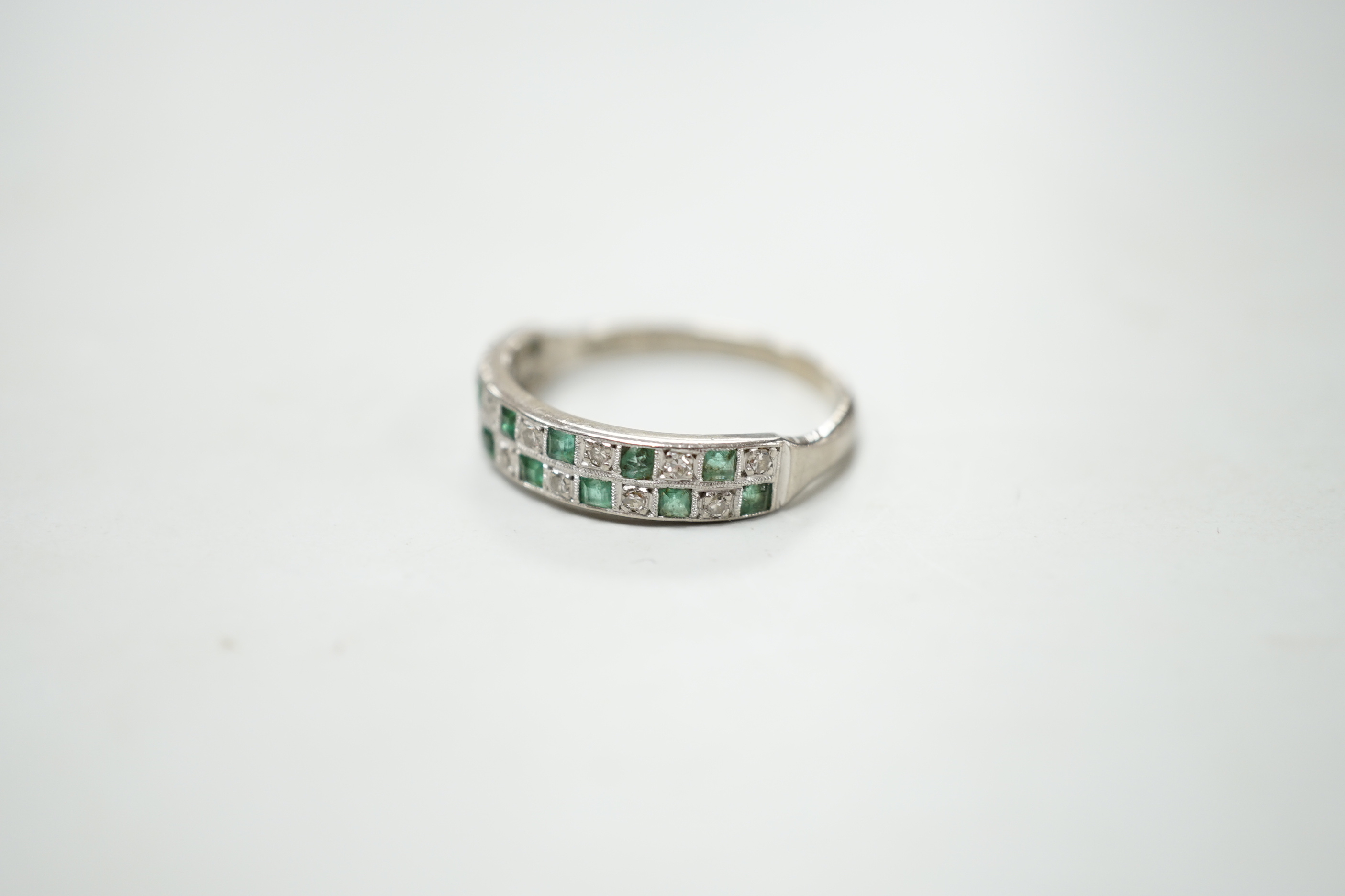 A modern 18ct white gold and two row emerald and diamond cluster set half hoop ring, size S, gross weight 4.5 grams.